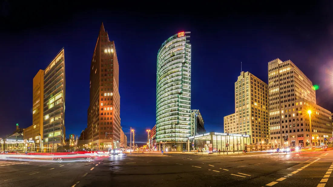 Office towers around Potsdamer Platz in Berlin lit up against a deep blue night sky