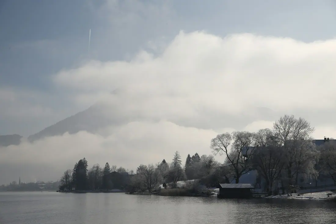 Cloud over the hills above Lake Tegernsee, with a boathouse on the shore